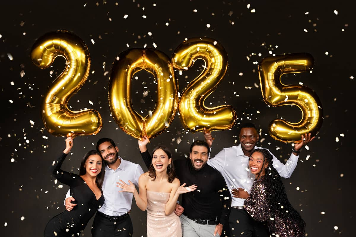 a group of men and women holding 2025 new year balloons