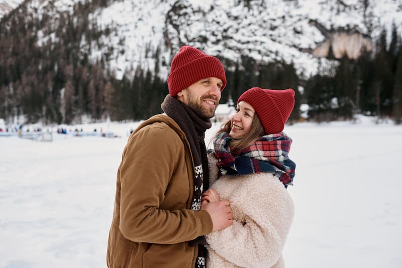 Couple dressed for winter standing close together on a snowy winter day